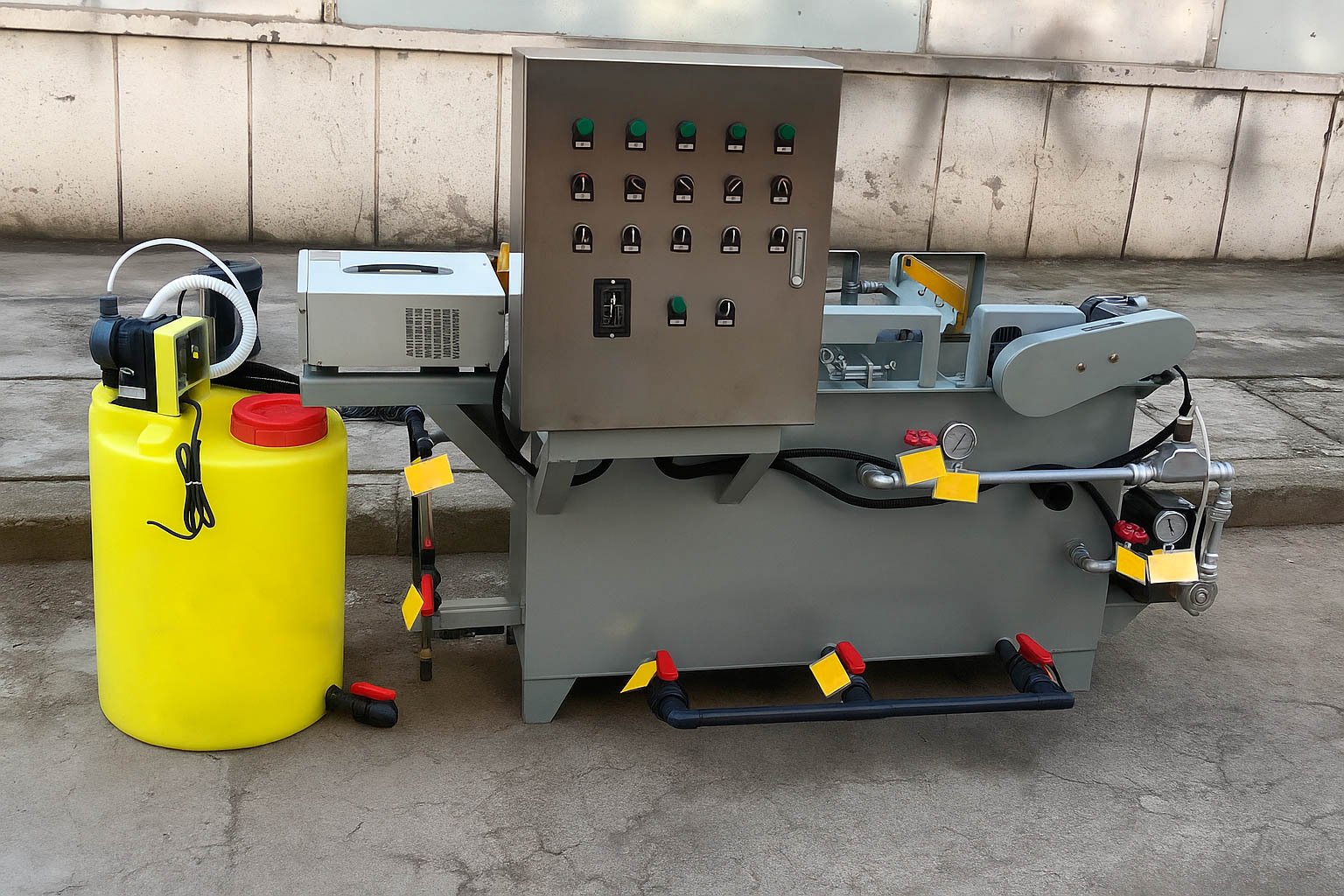 Técnico inspeccionando una planta de tratamiento de aguas residuales modular de color verde marca BIOMAX SYNERTECH, que incluye módulos de pretratamiento, decantación, DAF y oxidación avanzada. La planta está ubicada en un entorno industrial con techo alto y tuberías visibles. - ver más información